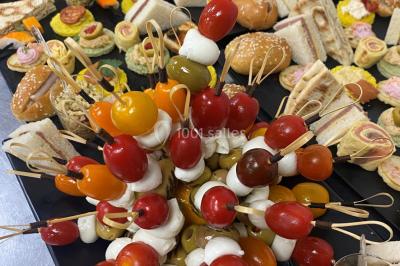 Buffet avec assiettes de salades variées, légumes frais et condiments, disposées sur une table éclairée.