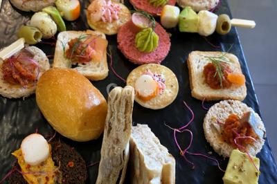 Buffet avec assiettes de salades variées, légumes frais et condiments, disposées sur une table éclairée.
