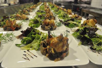 Buffet avec assiettes de salades variées, légumes frais et condiments, disposées sur une table éclairée.