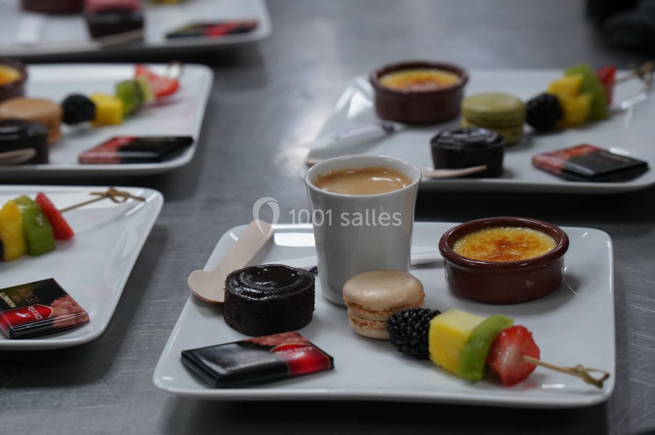 Assiette de desserts variés avec crème brûlée, macaron, fruits frais, gâteau au chocolat et café.