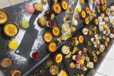 Buffet avec assiettes de salades variées, légumes frais et condiments, disposées sur une table éclairée.
