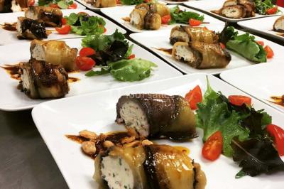 Buffet avec assiettes de salades variées, légumes frais et condiments, disposées sur une table éclairée.