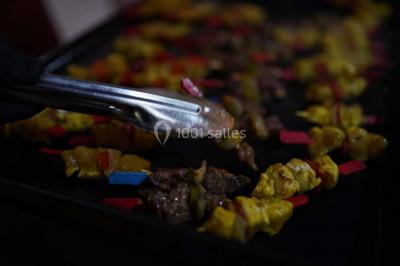 Buffet avec assiettes de salades variées, légumes frais et condiments, disposées sur une table éclairée.