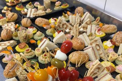 Buffet avec assiettes de salades variées, légumes frais et condiments, disposées sur une table éclairée.