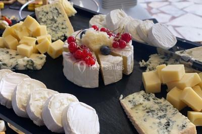 Buffet avec assiettes de salades variées, légumes frais et condiments, disposées sur une table éclairée.