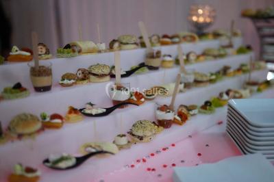 Buffet avec assiettes de salades variées, légumes frais et condiments, disposées sur une table éclairée.