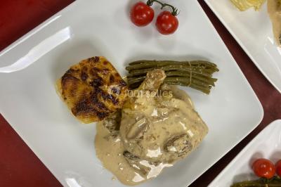 Buffet avec assiettes de salades variées, légumes frais et condiments, disposées sur une table éclairée.