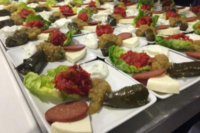 Buffet avec assiettes de salades variées, légumes frais et condiments, disposées sur une table éclairée.