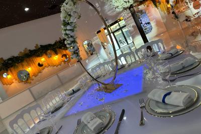 Buffet avec assiettes de salades variées, légumes frais et condiments, disposées sur une table éclairée.