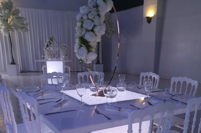 Buffet avec assiettes de salades variées, légumes frais et condiments, disposées sur une table éclairée.