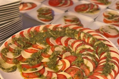 Buffet avec assiettes de salades variées, légumes frais et condiments, disposées sur une table éclairée.