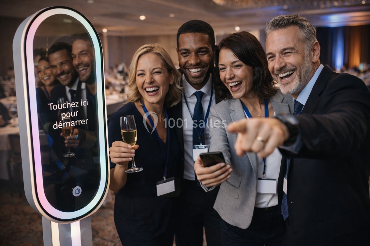 Des collègues souriants posent devant une borne photo interactive lors d'un événement professionnel.