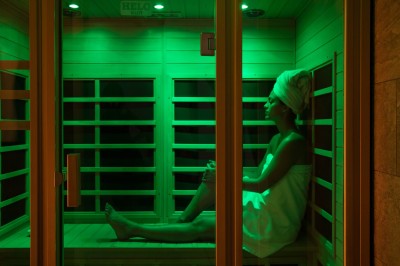 Chambre lumineuse avec lit double, table en bois, chaise beige, miroir et grande fenêtre avec stores.