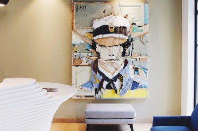 Chambre lumineuse avec lit double, table en bois, chaise beige, miroir et grande fenêtre avec stores.