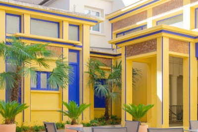 Salle de bain lumineuse avec un double lavabo, un grand miroir, une baignoire et des murs carrelés clairs.