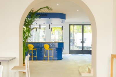 Salle de bain lumineuse avec un double lavabo, un grand miroir, une baignoire et des murs carrelés clairs.