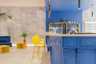 Salle de bain lumineuse avec un double lavabo, un grand miroir, une baignoire et des murs carrelés clairs.