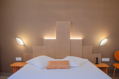 Salle de bain lumineuse avec un double lavabo, un grand miroir, une baignoire et des murs carrelés clairs.