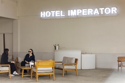 Salle de bain lumineuse avec un double lavabo, un grand miroir, une baignoire et des murs carrelés clairs.