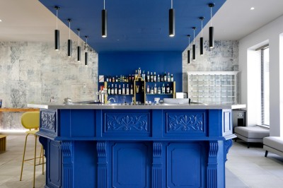 Salle de bain lumineuse avec un double lavabo, un grand miroir, une baignoire et des murs carrelés clairs.