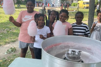 Des crêpes en cours de préparation sur des crêpières électriques, avec des personnes en arrière-plan.