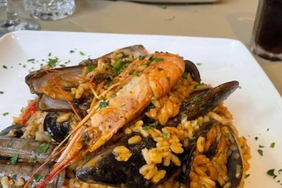 Des crêpes en cours de préparation sur des crêpières électriques, avec des personnes en arrière-plan.