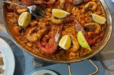 Des crêpes en cours de préparation sur des crêpières électriques, avec des personnes en arrière-plan.