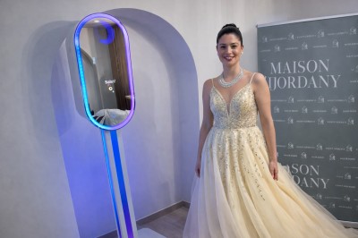 Deux personnes souriantes posant avec des accessoires festifs devant un fond scintillant rose.