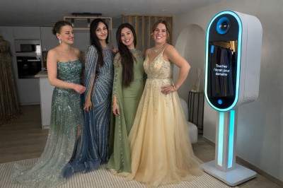 Deux personnes souriantes posant avec des accessoires festifs devant un fond scintillant rose.