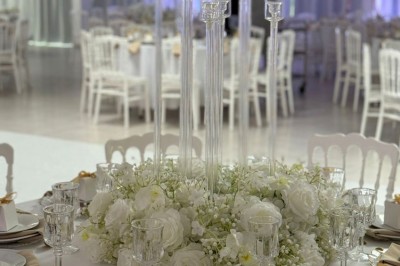 Miniature Location salle Mundolsheim (Bas-Rhin) - Le Joyau #7 Bougeoirs dorés élancés avec des fleurs blanches en décoration sur une table dans une salle de réception élégante.
