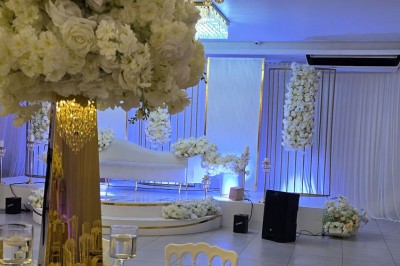 Miniature Location salle Mundolsheim (Bas-Rhin) - Le Joyau #13 Bougeoirs dorés élancés avec des fleurs blanches en décoration sur une table dans une salle de réception élégante.