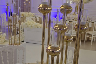 Miniature Location salle Mundolsheim (Bas-Rhin) - Le Joyau #14 Bougeoirs dorés élancés avec des fleurs blanches en décoration sur une table dans une salle de réception élégante.