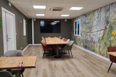 Cuisine professionnelle avec plans de travail en inox, étagères garnies d'ustensiles et équipements de nettoyage.