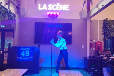 Cuisine professionnelle avec plans de travail en inox, étagères garnies d'ustensiles et équipements de nettoyage.