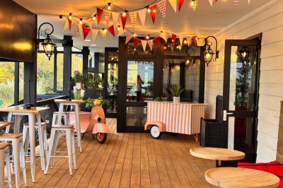 Cuisine professionnelle avec plans de travail en inox, étagères garnies d'ustensiles et équipements de nettoyage.