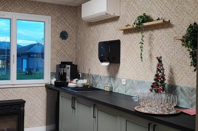 Cuisine professionnelle avec plans de travail en inox, étagères garnies d'ustensiles et équipements de nettoyage.