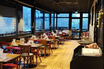 Cuisine professionnelle avec plans de travail en inox, étagères garnies d'ustensiles et équipements de nettoyage.