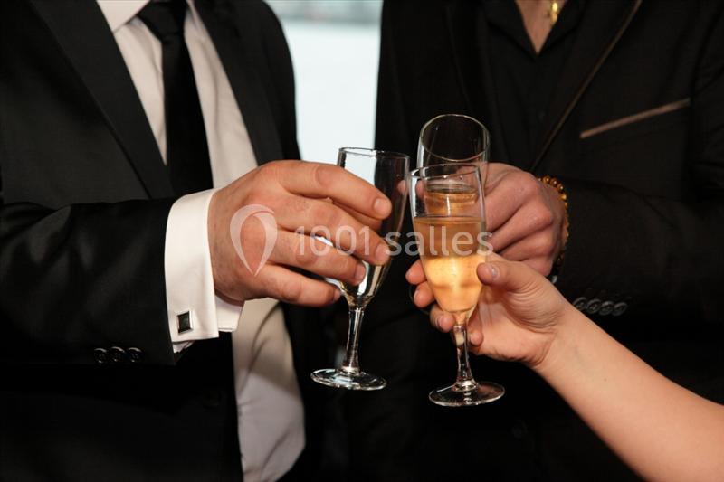 Trois personnes trinquent avec des flûtes de champagne lors d'une occasion formelle.