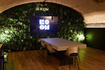 Miniature Location salle Strasbourg (Bas-Rhin) - La Room #2 Terrasse extérieure avec table, chaises métalliques, mur végétalisé et sol en gazon synthétique, entourée de bambous.