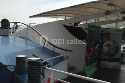 Un groupe de personnes pose sur une scène éclairée, accompagné d'une mascotte en costume d'ours.