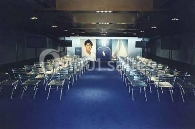 Un groupe de personnes pose sur une scène éclairée, accompagné d'une mascotte en costume d'ours.