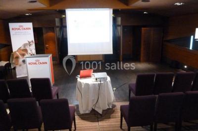Un groupe de personnes pose sur une scène éclairée, accompagné d'une mascotte en costume d'ours.