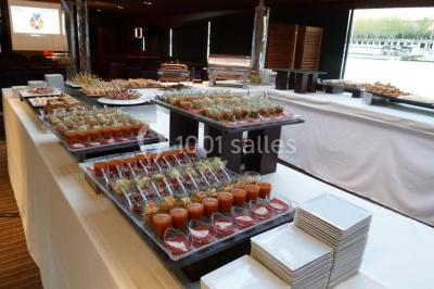Un groupe de personnes pose sur une scène éclairée, accompagné d'une mascotte en costume d'ours.