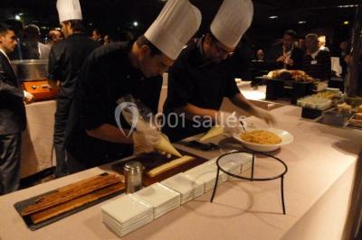 Un groupe de personnes pose sur une scène éclairée, accompagné d'une mascotte en costume d'ours.