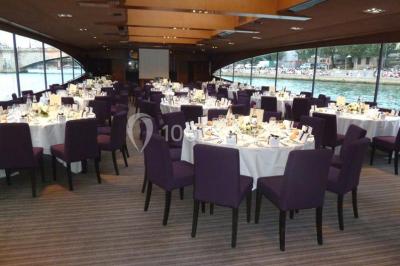 Un groupe de personnes pose sur une scène éclairée, accompagné d'une mascotte en costume d'ours.