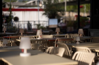 Miniature Location salle Paris 13 (Paris) - Plat/Form #10 Terrasse d'un café avec des tables et des chaises vides, éclairées par des lampes de table en plein jour.