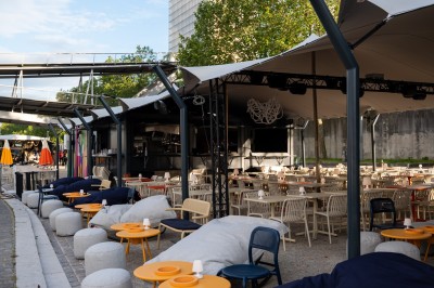 Miniature Location salle Paris 13 (Paris) - Plat/Form #7 Terrasse d'un café avec des tables et des chaises vides, éclairées par des lampes de table en plein jour.