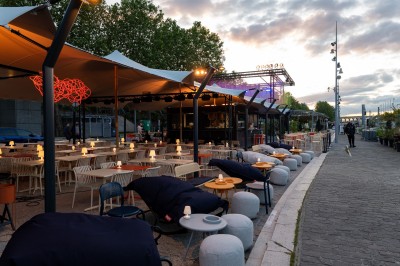 Miniature Location salle Paris 13 (Paris) - Plat/Form #2 Terrasse d'un café avec des tables et des chaises vides, éclairées par des lampes de table en plein jour.