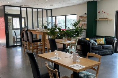 Salle de réunion avec une table dressée contenant des boissons, fruits, viennoiseries et matériel de présentation.