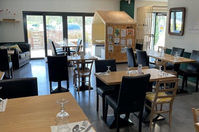 Salle de réunion avec une table dressée contenant des boissons, fruits, viennoiseries et matériel de présentation.